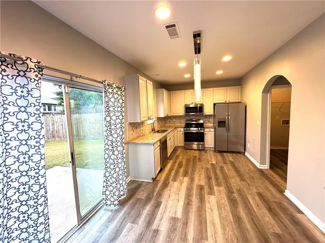 a kitchen with granite countertop a refrigerator and a sink