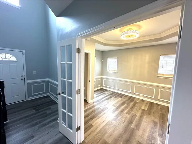 a view of a hallway with wooden floor and staircase