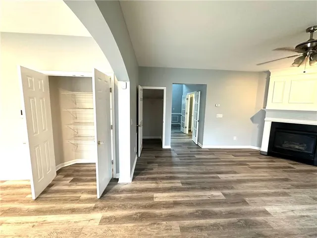 a view of a livingroom with wooden floor and kitchen view
