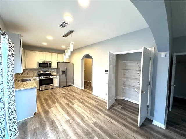 a kitchen with stainless steel appliances granite countertop a refrigerator and a sink
