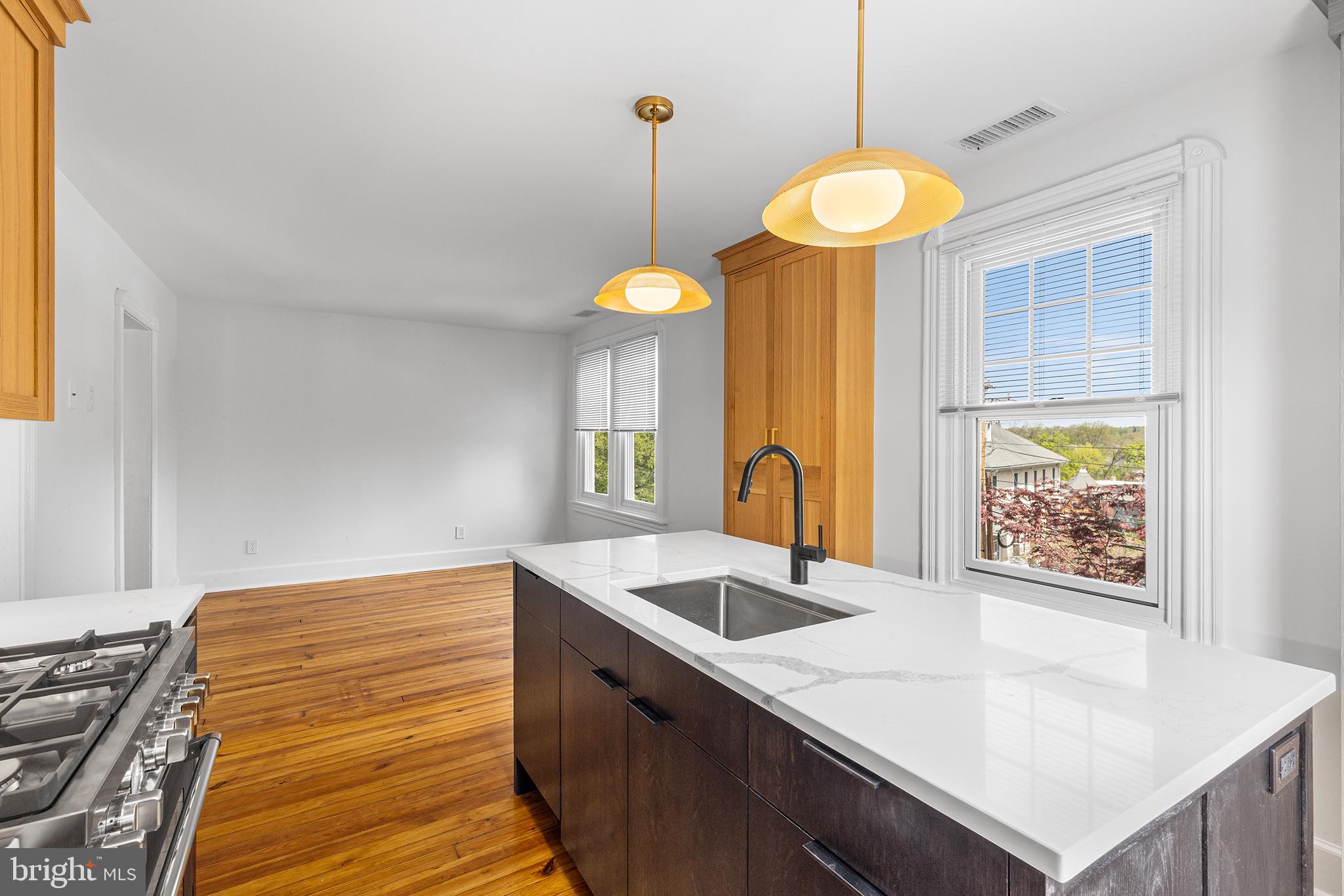 250 Conestoga Road, Unit 2 Wayne, PA 19087 - Photo 11 of 24 a kitchen with a sink chandelier and a stove
