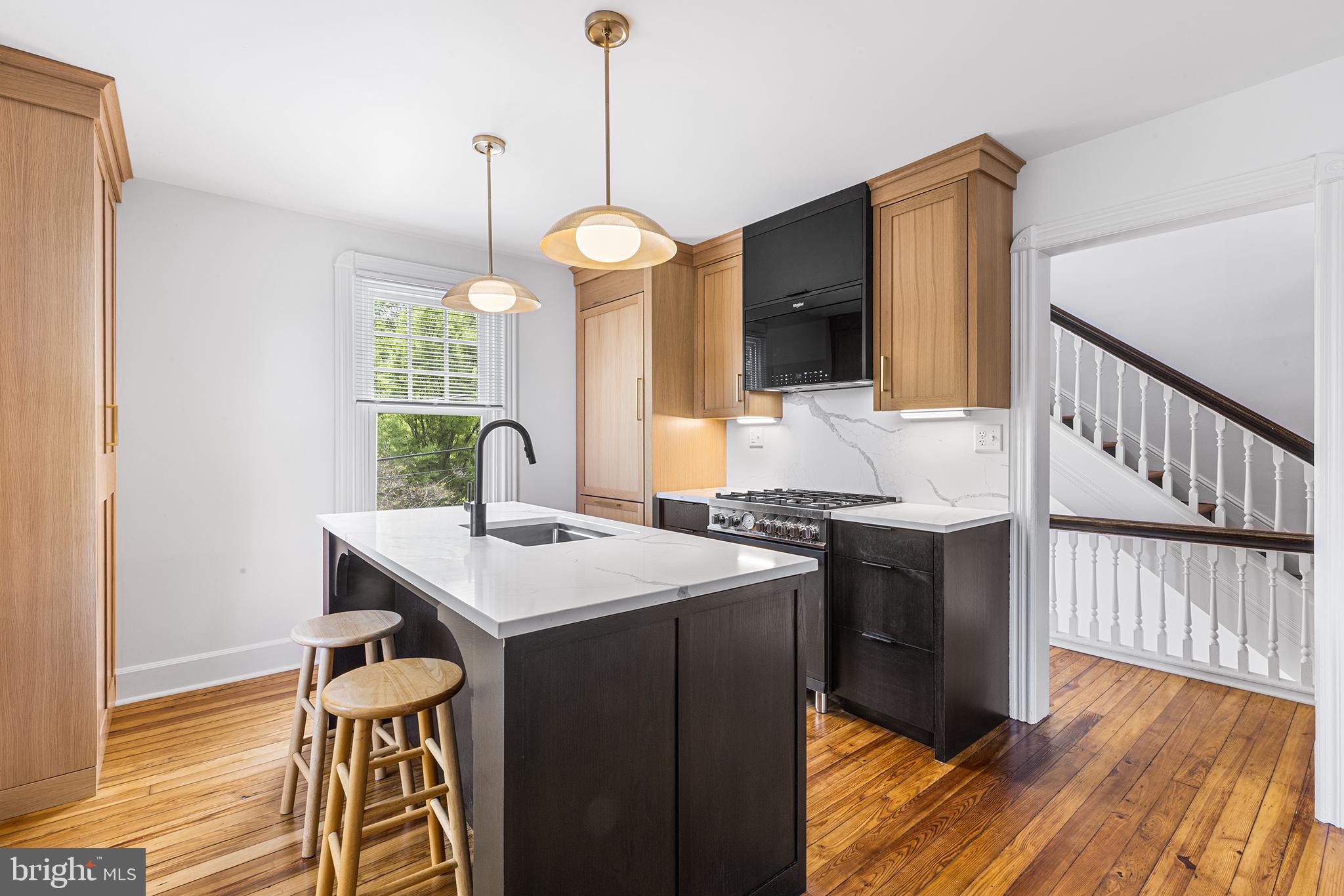 250 Conestoga Road, Unit 2 Wayne, PA 19087 - Photo 6 of 24 a view of kitchen island with furniture and wooden floor