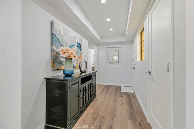 a very nice looking hallway with a chair and a potted plant