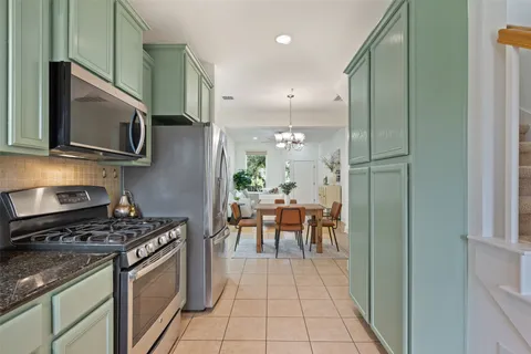 a kitchen with stainless steel appliances granite countertop a stove a microwave and a refrigerator