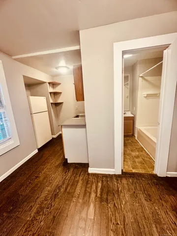 a view of empty room with wooden floor