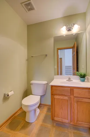 a bathroom with a granite countertop toilet sink and mirror