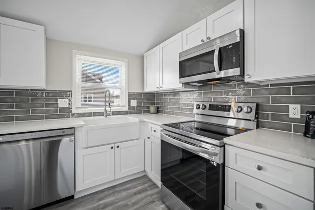 a kitchen with cabinets stainless steel appliances and a sink
