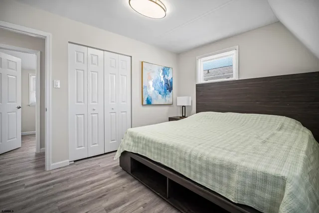 a spacious bedroom with a bed and wooden floor
