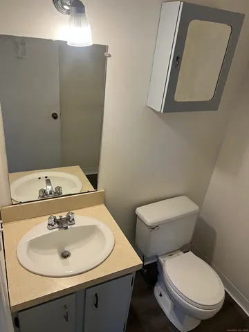 a bathroom with a toilet sink and mirror