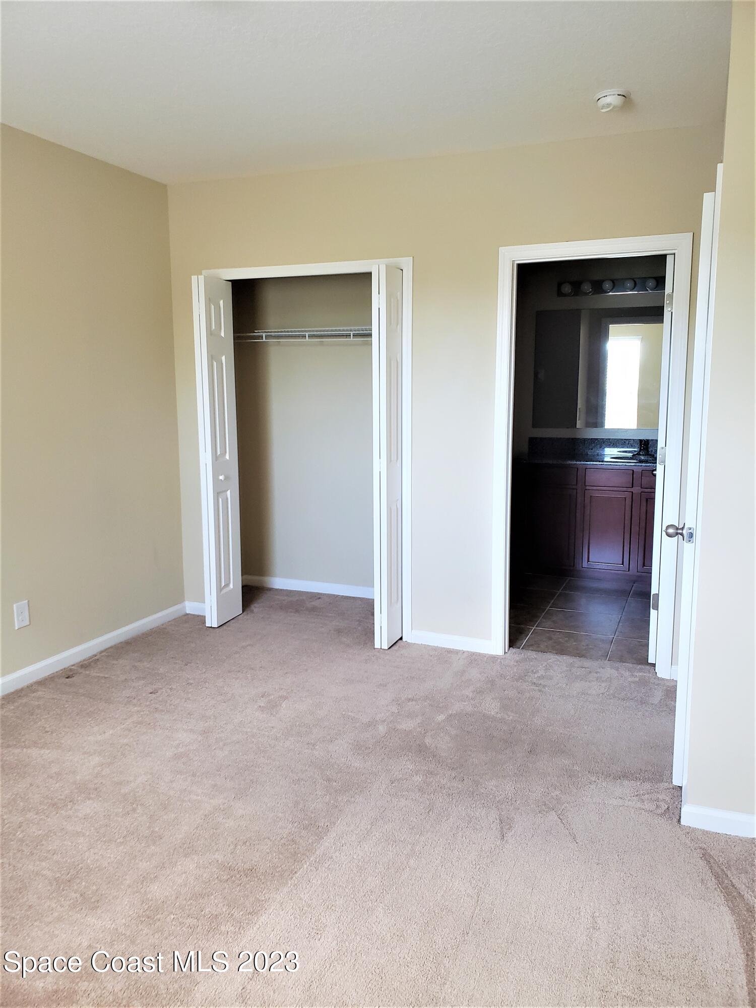 2575 Revolution Street, Unit 105 Melbourne, FL 32935 - Photo 12 of 38 a view of an empty room with closet and wooden floor
