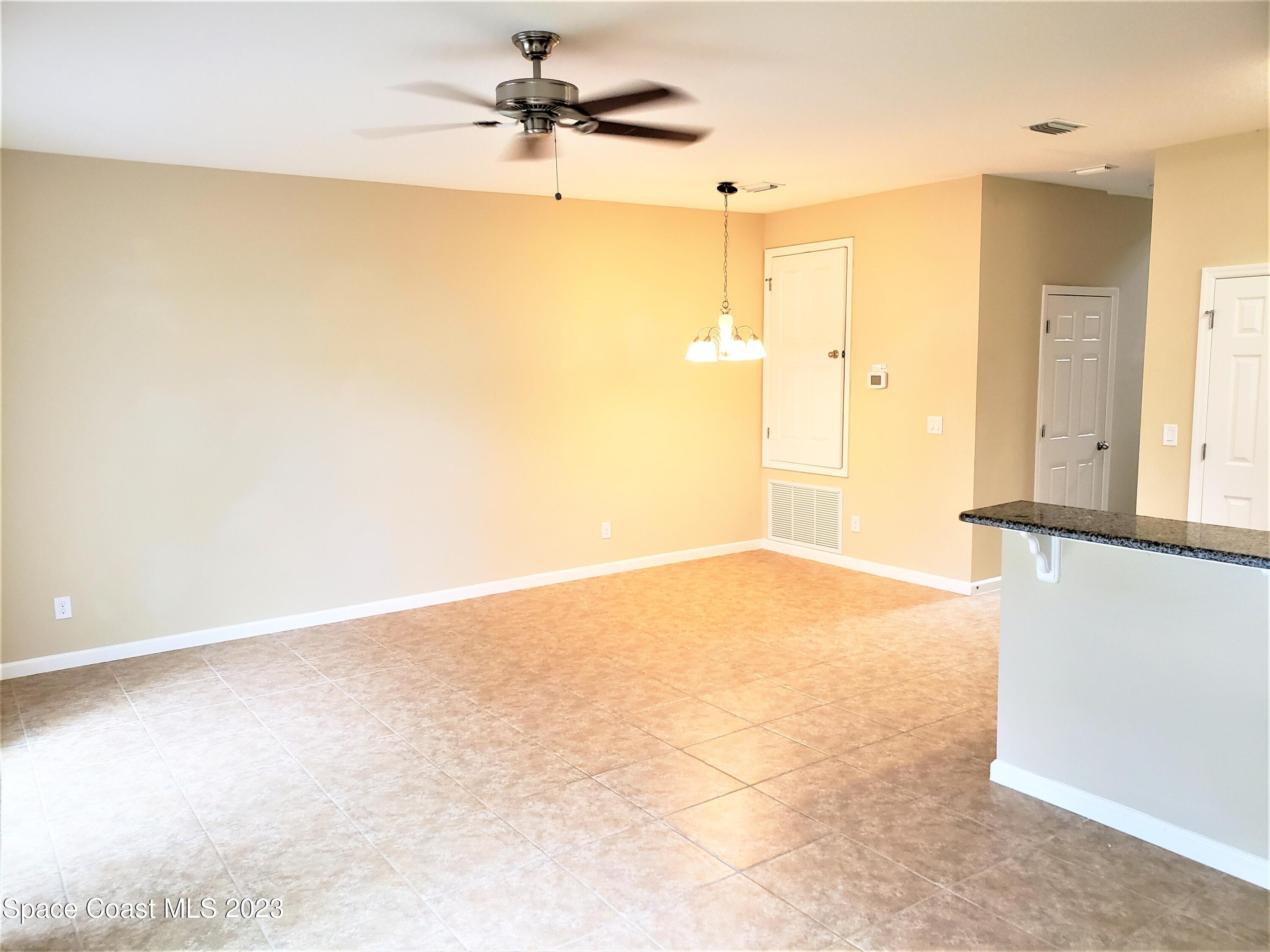 2575 Revolution Street, Unit 105 Melbourne, FL 32935 - Photo 4 of 38 an empty room with a empty space and a ceiling fan