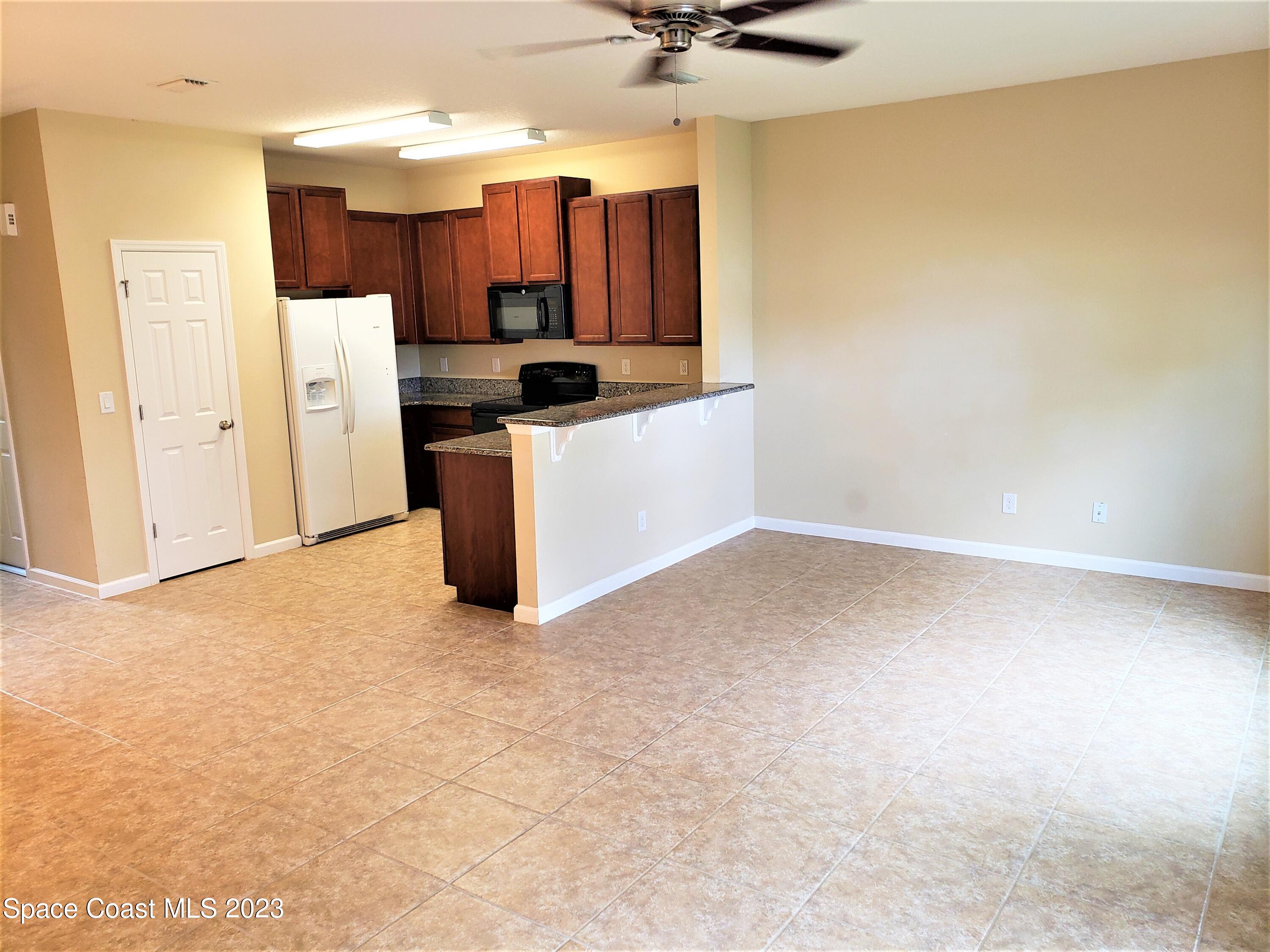 2575 Revolution Street, Unit 105 Melbourne, FL 32935 - Photo 5 of 38 a kitchen with a refrigerator and a sink