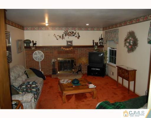 48 Pinecrest Road Somerset, NJ 08873 - Photo 4 of 10 a living room with furniture a flat screen tv and a fireplace