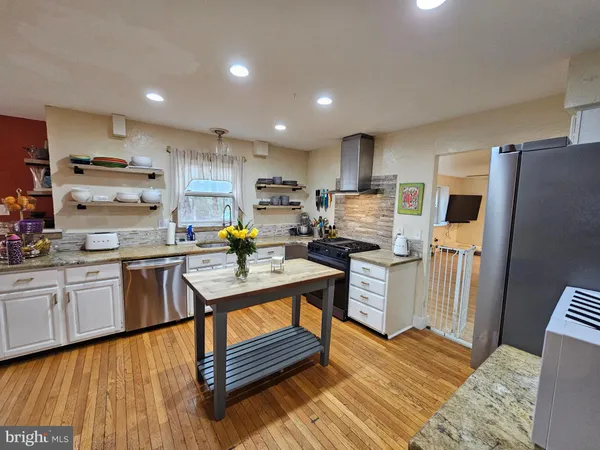 a kitchen with refrigerator cabinets and wooden floor