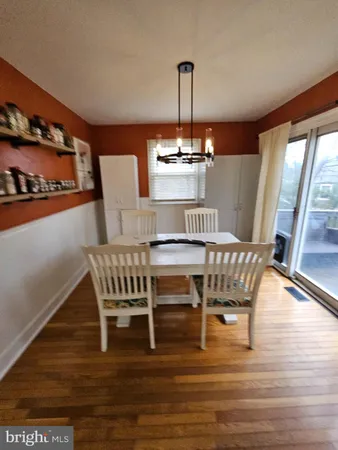 a view of a dining room with furniture wooden floor and a floor to ceiling window