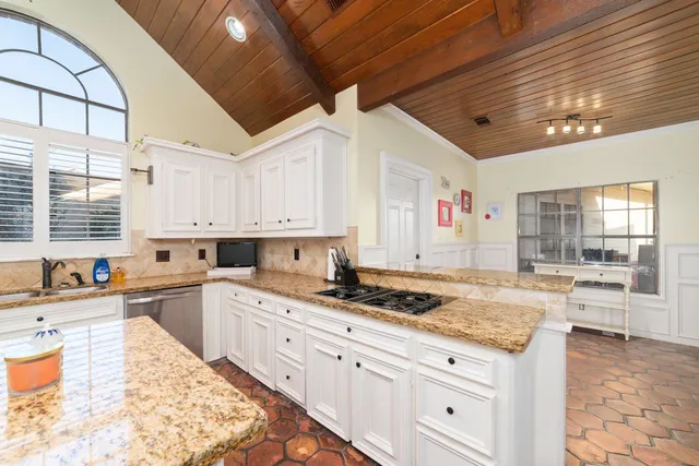 a kitchen with granite countertop a sink and cabinets