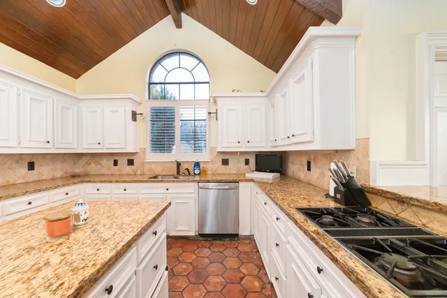 a kitchen with a stove a sink and a window