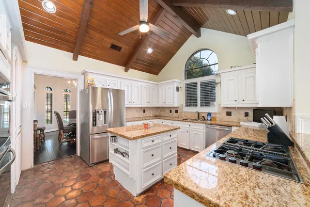 a kitchen with a stove a refrigerator and cabinets