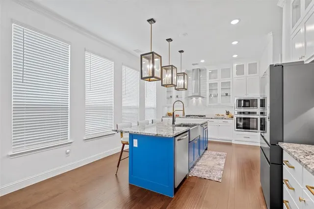 a kitchen with stainless steel appliances granite countertop a sink a stove and a refrigerator