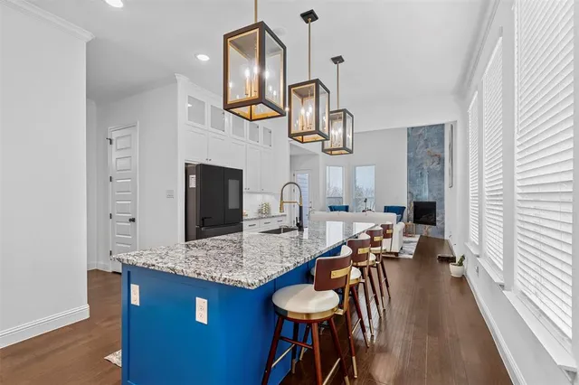 a kitchen with stainless steel appliances granite countertop a sink a stove and a wooden floors