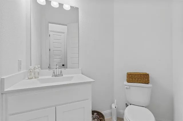 a bathroom with a toilet sink vanity and mirror