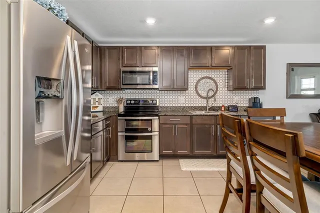a kitchen with stainless steel appliances kitchen island granite countertop a sink and cabinets