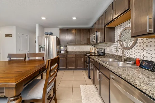 a dining table chair a refrigerator and a stove