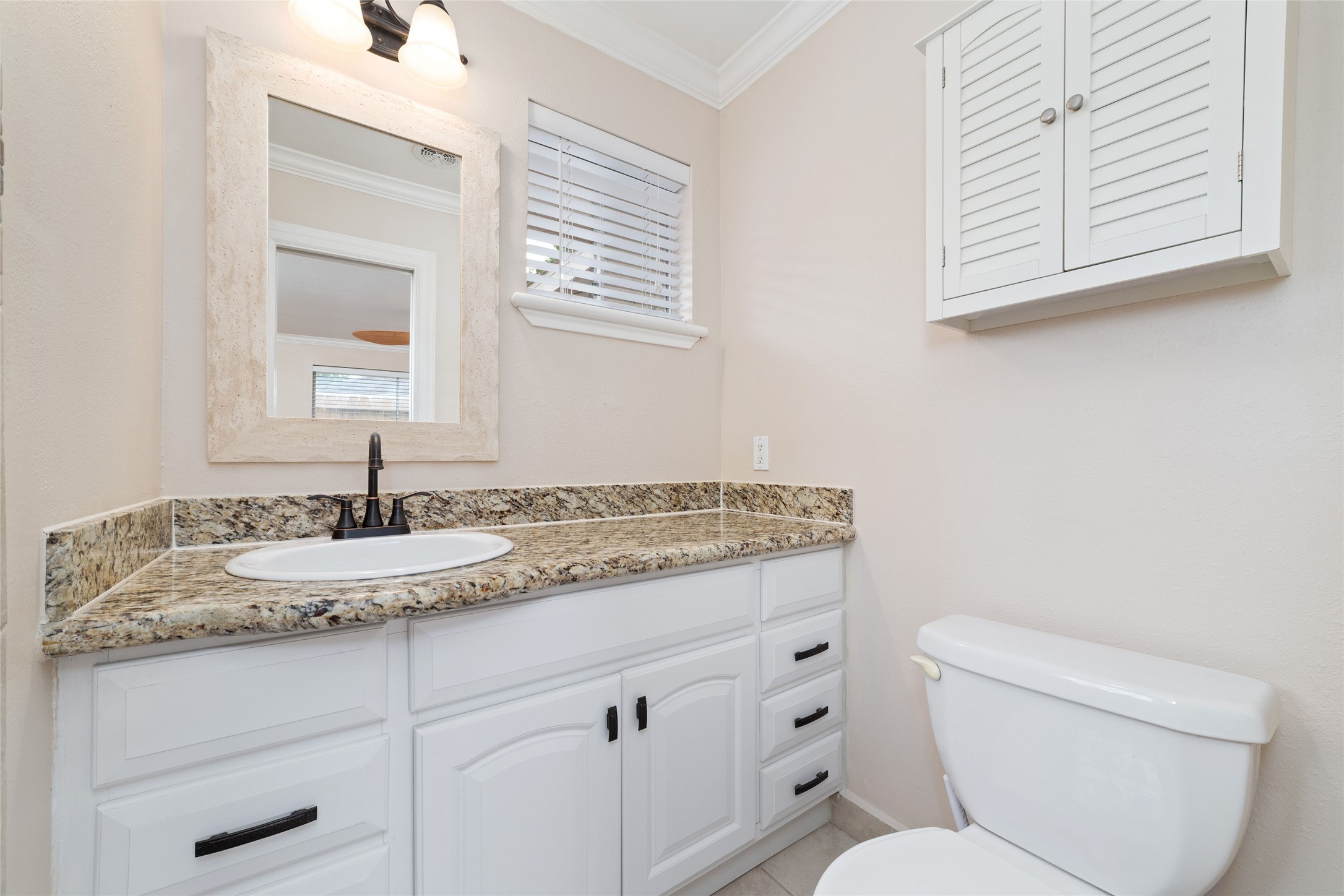 5643 Cheena Drive Houston, TX 77096 - Photo 23 of 32 a bathroom with a granite countertop toilet sink and mirror