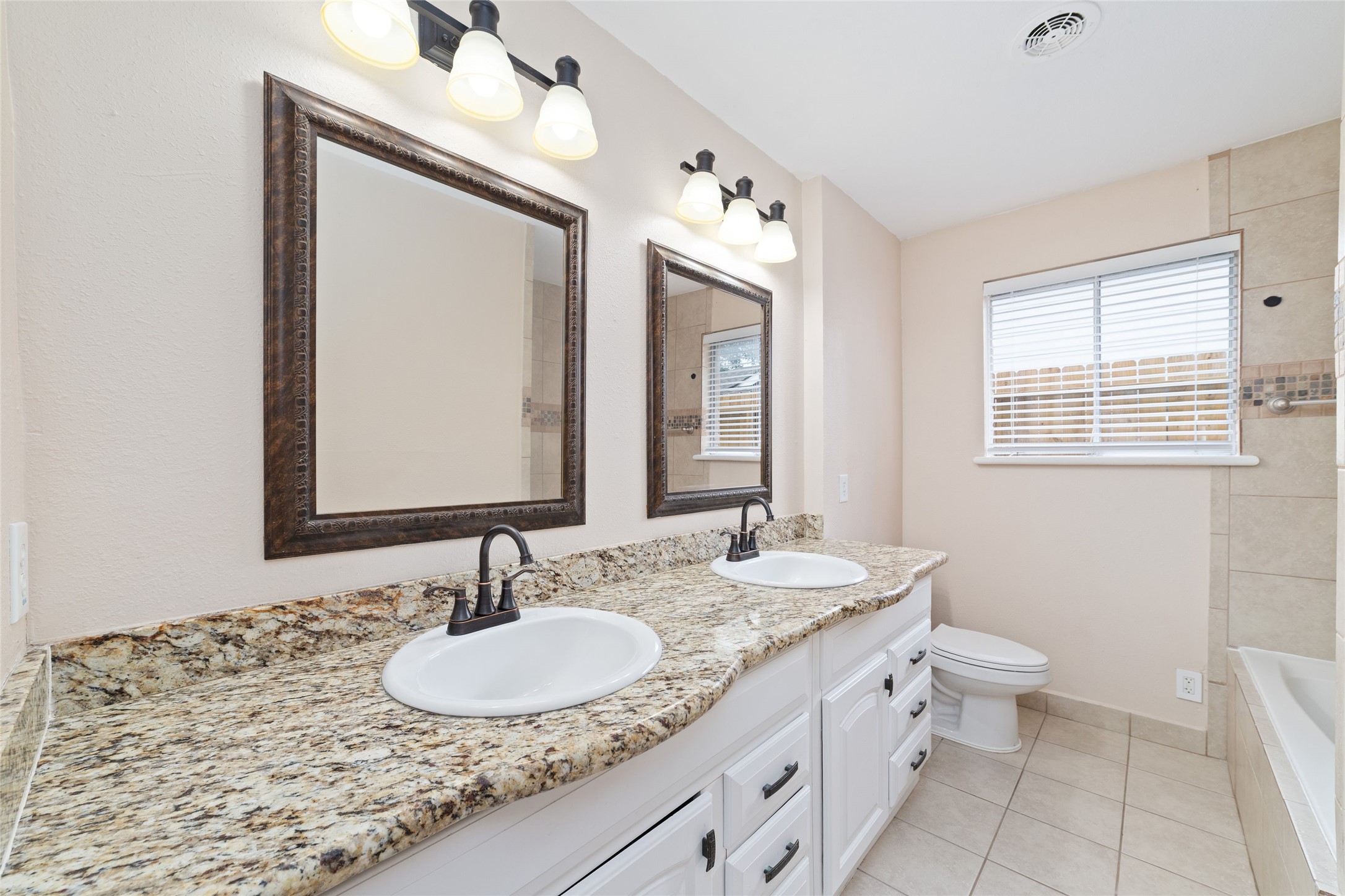 5643 Cheena Drive Houston, TX 77096 - Photo 28 of 32 a bathroom with a granite countertop sink a large mirror and a toilet