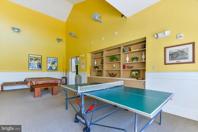 a room with pool table and a bookshelf