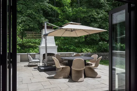 a view of a patio with table and chairs under an umbrella