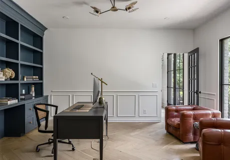 a view of a workspace with furniture and a window