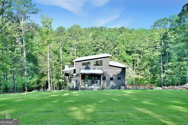 a living room with furniture kitchen view and large windows
