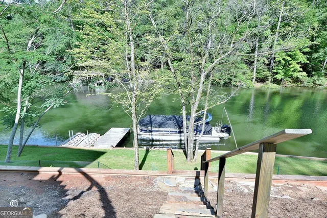 a kitchen with kitchen island granite countertop a sink a stove and chairs