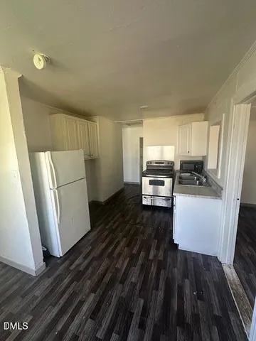 a kitchen view with wooden floor and electronic appliances