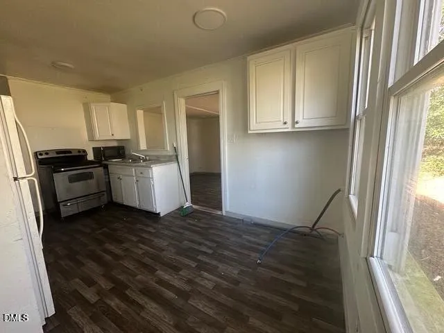a kitchen with granite countertop a refrigerator and a stove top oven