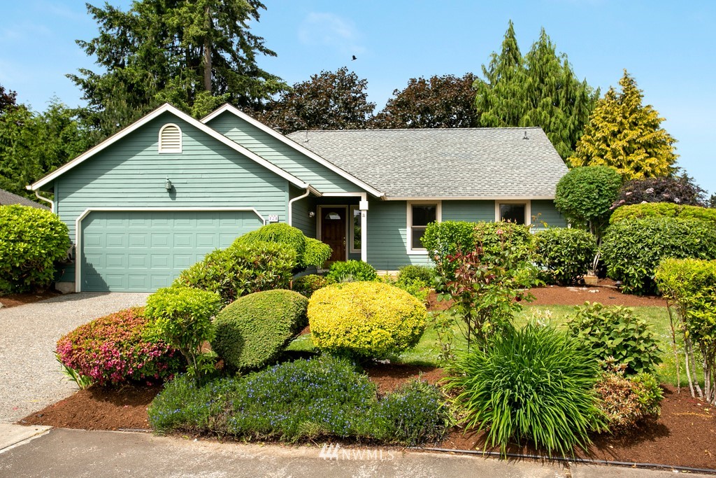 121 Union Court Northeast Renton, WA 98059 - Photo 2 of 21 a view of a house with a small yard plants and large trees