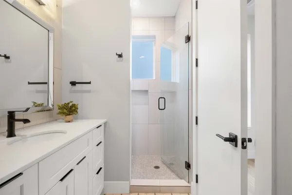 an empty room with wooden floor a ceiling fan and windows