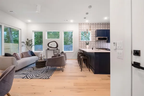 a living room with furniture a large window and a flat screen tv