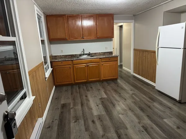 a kitchen with granite countertop a refrigerator and a stove