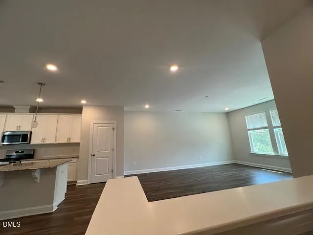 a kitchen with stainless steel appliances a refrigerator and wooden floor