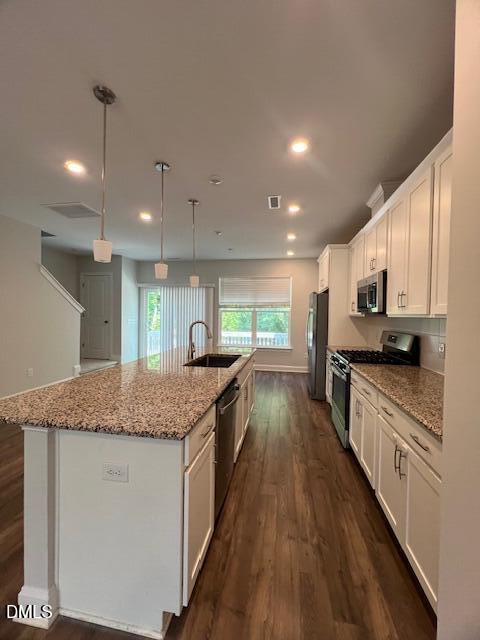 2819 Macbeth Lane Apex, NC 27502 - Photo 16 of 62 a kitchen with stainless steel appliances granite countertop a sink a stove top oven a counter space and cabinets