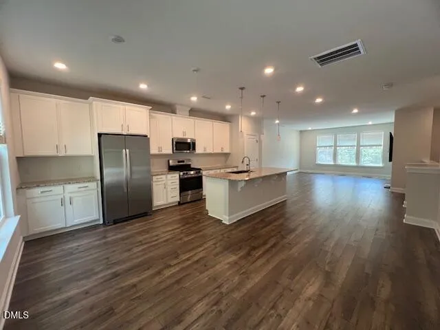 a view of a living room with a flat screen tv and wooden floor