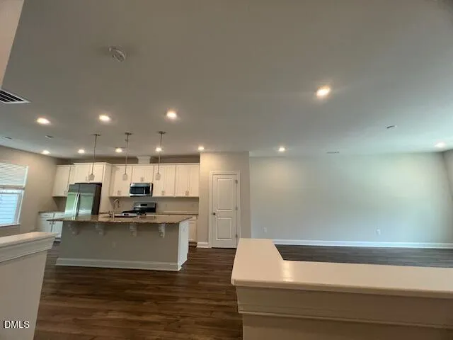 a kitchen with granite countertop a stove a sink and a refrigerator