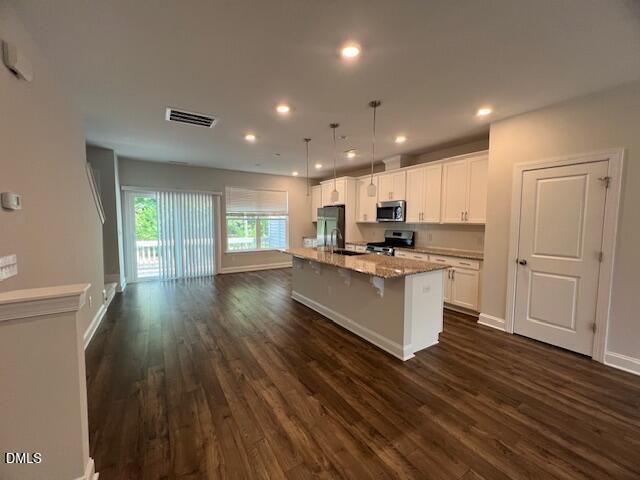 2819 Macbeth Lane Apex, NC 27502 - Photo 9 of 62 a kitchen with granite countertop a stove a sink and a refrigerator