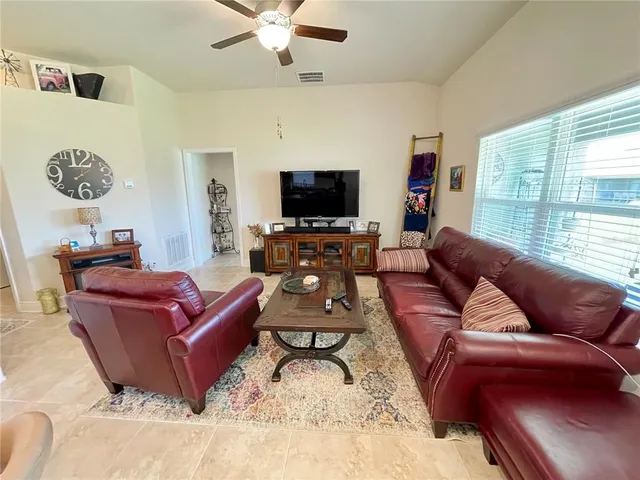 a living room with furniture a flat screen tv and a window