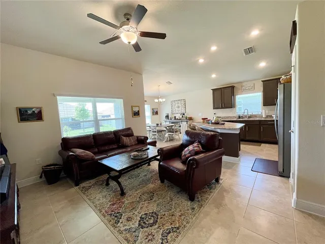 a living room with furniture kitchen view and a window