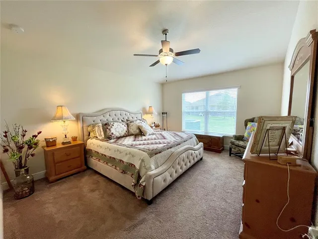 a bedroom with a bed couch and a large window