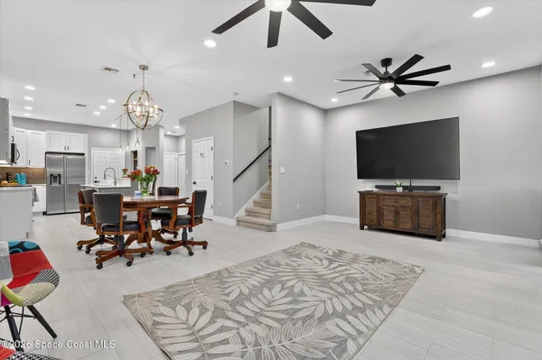 a kitchen with white cabinets and chairs