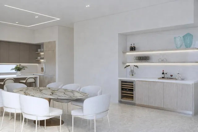 a kitchen with a dining table chairs and white cabinets